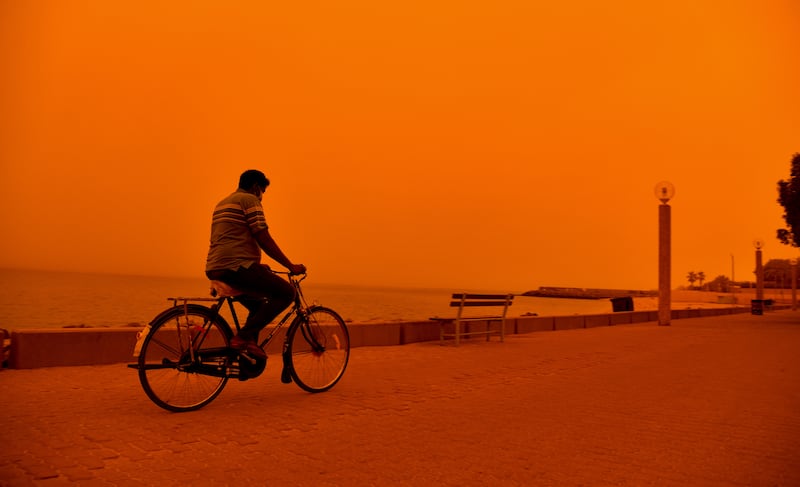 A man rides a bicycle during a heavy dust storm in Kuwait City. EPA