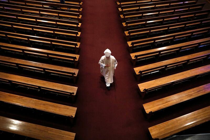 Bishop William Joensen proceeds down the main aisle at the conclusion of Holy Thursday Mass in a near empty St. Ambrose Cathedral in Des Moines, Iowa. AP Photo