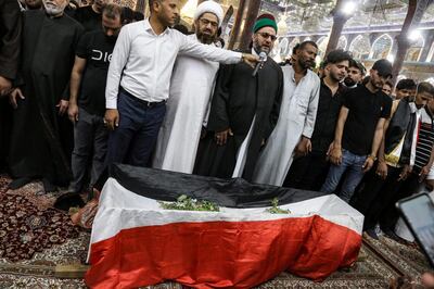 Mourners pray by the body of Iraqi anti-government activist Ihab al-Wazni (Ehab al-Ouazni) during his funeral at the Imam Hussein Shrine in the central holy shrine city of Karbala on May 9, 2021. Wazni, a coordinator of protests in the Shiite shrine city of Karbala, was a vocal opponent of corruption, the stranglehold of Tehran-linked armed groups and Iran's influence in Iraq. He was shot overnight outside his home by men on motorbikes, in an ambush caught on surveillance cameras. He had narrowly escaped death in December 2019, when men on motorbikes used silenced weapons to kill fellow activist Fahem al-Tai as he was dropping him home in Karbala, where pro-Tehran armed groups are legion. / AFP / Mohammed SAWAF
