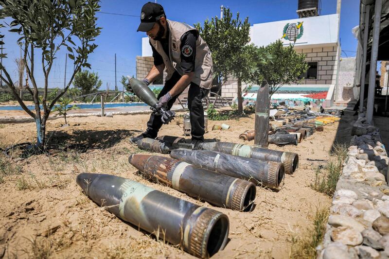 An official of the Palestinian group Hamas lays out unexploded projectiles after the May 2021 conflict with Israel, at a police station in Khan Yunis in the southern Gaza Strip. AFP