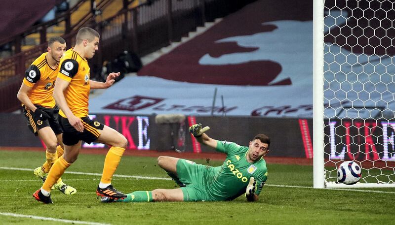 Wolverhampton Wanderers' English defender Conor Coady has a shot saved by Aston Villa's Argentinian goalkeeper Emiliano Martinez (R) during the English Premier League football match between Aston Villa and Wolverhampton Wanderers at Villa Park in Birmingham, central England on March 6, 2021. (Photo by PETER CZIBORRA / POOL / AFP) / RESTRICTED TO EDITORIAL USE. No use with unauthorized audio, video, data, fixture lists, club/league logos or 'live' services. Online in-match use limited to 120 images. An additional 40 images may be used in extra time. No video emulation. Social media in-match use limited to 120 images. An additional 40 images may be used in extra time. No use in betting publications, games or single club/league/player publications. / 