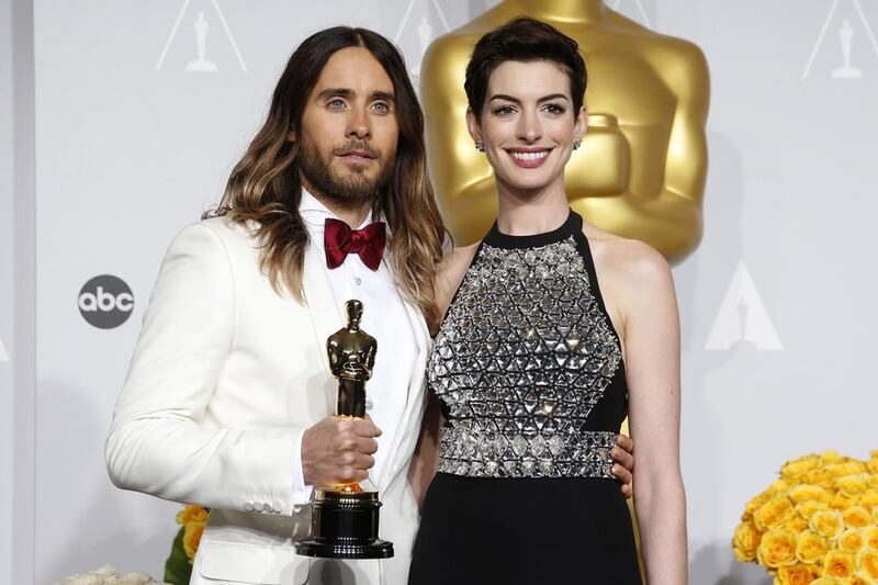 Jared Leto, best supporting actor for his role in Dallas Buyers Club, poses with presenter Anne Hathaway. Reuters