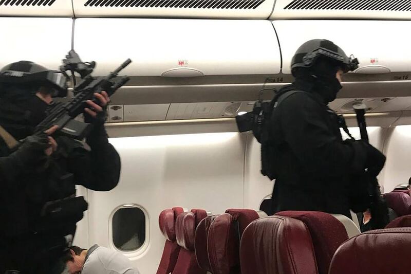 Heavily-armed police walk through Malaysia Airlines Flight MH128 to arrest a Sri Lankan man after the flight made an emergency landing in Melbourne. Andrew Leoncelli / AFP