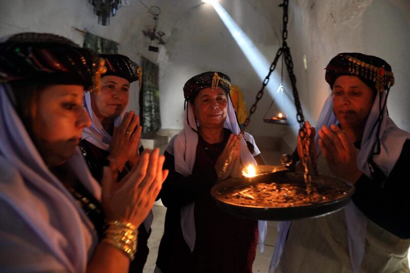 Iraqi Yazidi women pray at the Temple of Lalish, in a valley near the Kurdish city of Dohuk about 430km northwest of the capital Baghdad, on July 16, 2019. AFP