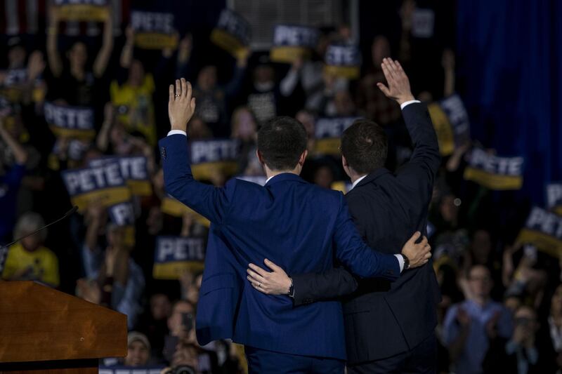 Pete Buttigieg, former mayor of South Bend and 2020 presidential candidate, and his husband Chasten Buttigieg wave to the crowd during a primary night rally in Nashua, New Hampshire, U.S. Bloomberg