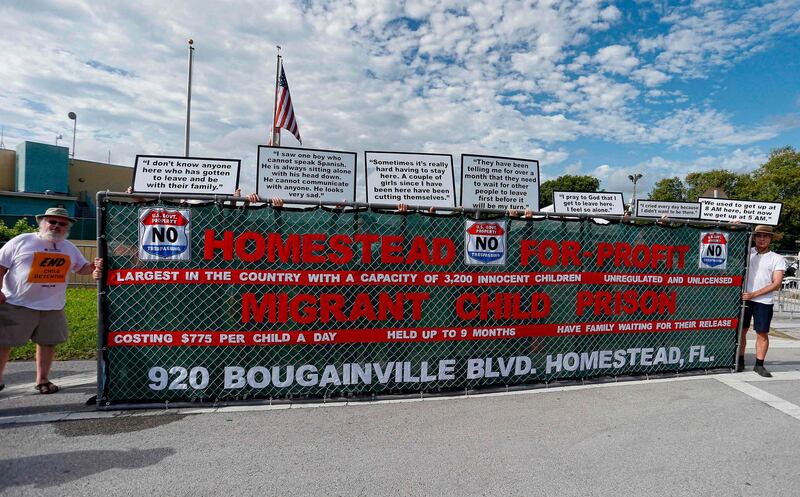 Activists hold a sign in front of a detention center in Homestead, Florida where migrant children who have been separated from their families are being held on June 28, 2019.  Public outcry over Trump's handling of the border crisis has increased dramatically after a migrant rights group revealed alarming detention conditions of migrant children in Texas, where children were deprived of showers and clean clothes for weeks. / AFP / RHONA WISE
