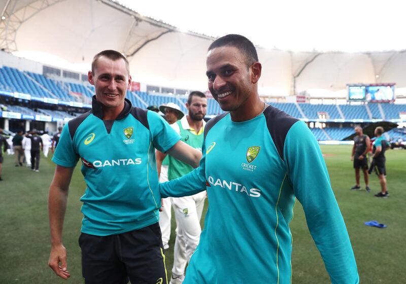 DUBAI, UNITED ARAB EMIRATES - OCTOBER 11: Usman Khawaja and Marnus Labuschagne of Australia  celebrate after Australia held on to draw the test match during day five of the First Test match in the series between Australia and Pakistan at Dubai International Stadium on October 11, 2018 in Dubai, United Arab Emirates. (Photo by Ryan Pierse/Getty Images)