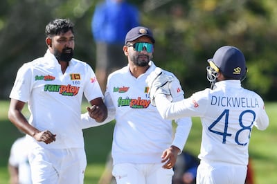 Sri Lanka's Prabath Jayasuriya, left, Dimuth Karunaratne, centre, and Niroshan Dickwella celebrate the wicket of New Zealand's Tom Latham. AFP