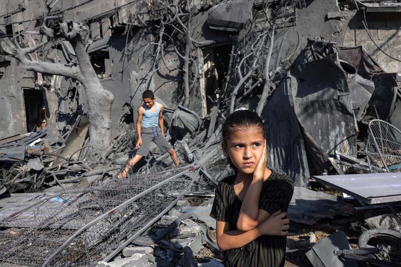 A girl looks on as she stands by the rubble outside a building that was hit by Israeli bombardment in Rafah, in the southern Gaza Strip. AFP