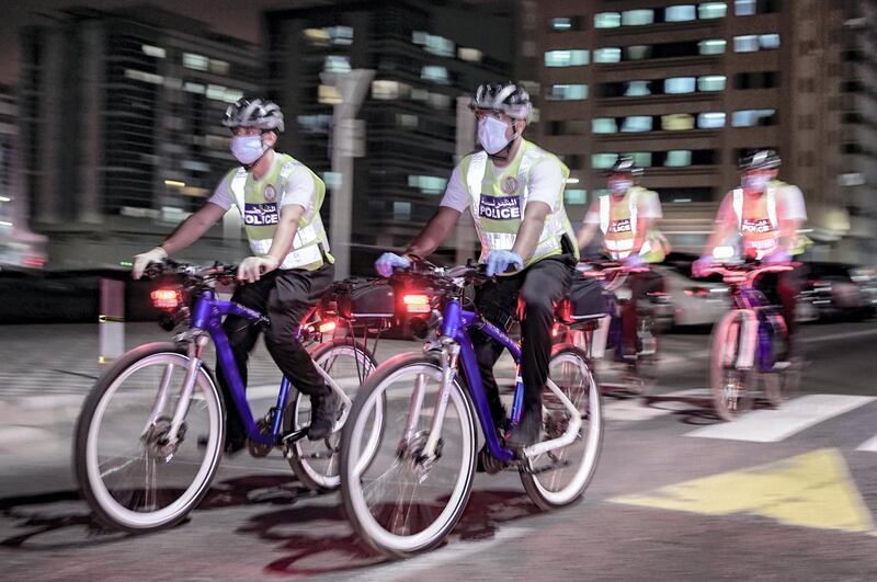 Abu Dhabi, United Arab Emirates, May 11, 2020.   Abu Dhabi Police bicycle patrol do night operations around the Mussaffah area to warn or catch curfew violators in the residential areas. --  Police officers start the nighttime operations.
Victor Besa / The National
Section:  NA
Reporter:  Haneen Dajani