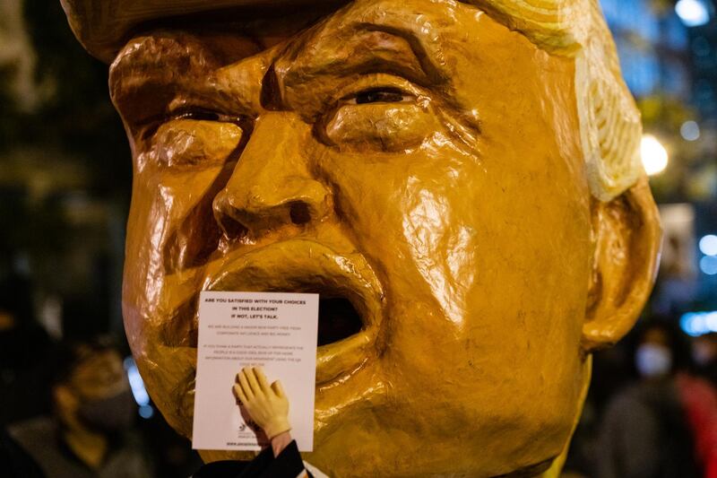A person wearing a mask resembling U.S. President Donald Trump hands out flyers at Black Lives Matter Plaza during the 2020 Presidential election in Washington, D.C. Bloomberg