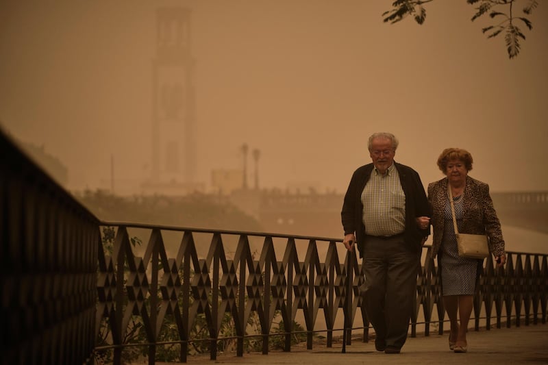 A couple walk across a bridge in a cloud of red dust in Santa Cruz de Tenerife, Spain. AP Photo