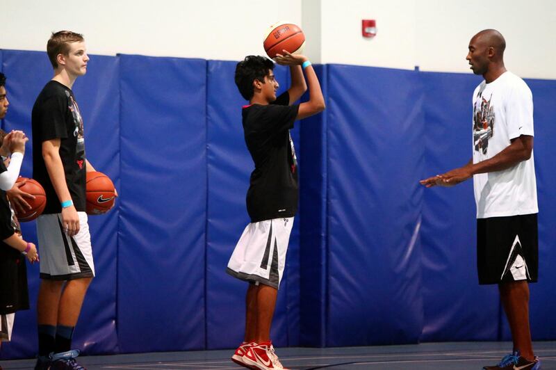 LA Lakers NBA player Kobe Bryant (R) leads a training session at the Gems American Academy in Abu Dhabi on September, 26, 2013. Bryant arrived for a Health and Fitness Weekend, to promote awareness of diabetes in the United Arab Emirates in his first trip to a Middle East country.          AFP PHOTO/MARWAN NAAMANI (Photo by MARWAN NAAMANI / AFP)