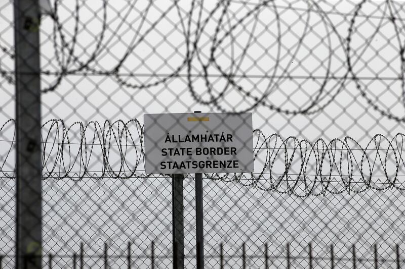 FILE - In this file photo dated Monday, April 8, 2019, a sign reading: "State Border" is attached to a fence at Hungary's border with Serbia near the village Asotthalom, Hungary.  The European Unionâ€™s border control agency Frontex, said Wednesday Jan. 27, 2021, it is suspending operations in Hungary after the government in Budapest did not comply with a ruling by Europeâ€™s highest court on the rights of asylum-seekers. (AP Photo/Darko Vojinovic, FILE)