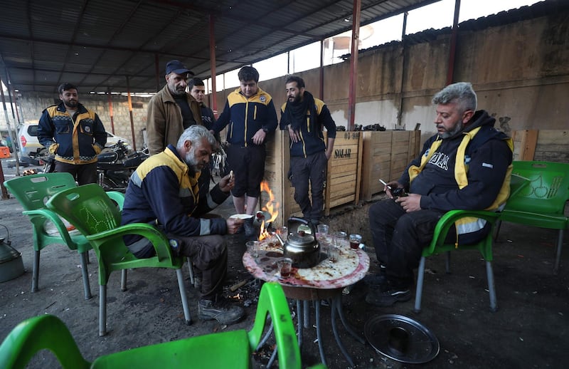 Members of the White Helmets keeping warm in Maaret al-Numan in Syria's southern Idlib governorate.  AFP