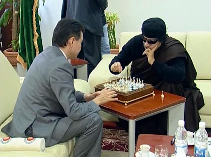 In this image taken from video on Sunday, June 12, 2011, provided by FIDE President Kirsan Ilyumzhinov's press service, Libyan leader Moammar Gadhafi, right, plays a game of chess with visiting president of the World Chess Federation Kirsan Ilyumzhinov in Tripoli, the capital of Libya. As the world awaits Moammar Gadhafi's next move, the Libyan leader has been playing chess with the visiting Russian head of the World Chess Federation. The federation is headed by the eccentric Kirsan Ilyumzhinov, who until last year was the leader of Russia's predominantly Buddhist republic of Kalmykia. He once claimed to have visited an alien spaceship. (AP Photo/FIDE Press service) EDITORIAL USE ONLY