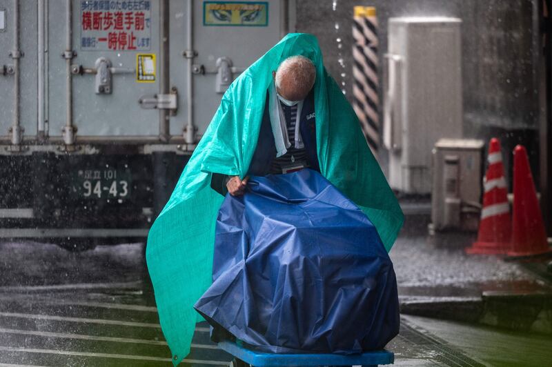 A maintenance worker in Tokyo battles against the weather. AFP