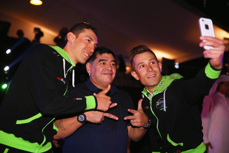DUBAI, UNITED ARAB EMIRATES - FEBRUARY 03:  Stefano Pirazzi (l) and Nicola Ruffoni (r) of Italy and Bardiani CSF take a selfie with Diego Maradona at the opening ceremony of the Dubai Tour on February 3, 2015 in Dubai, United Arab Emirates.  (Photo by Bryn Lennon/Getty Images)