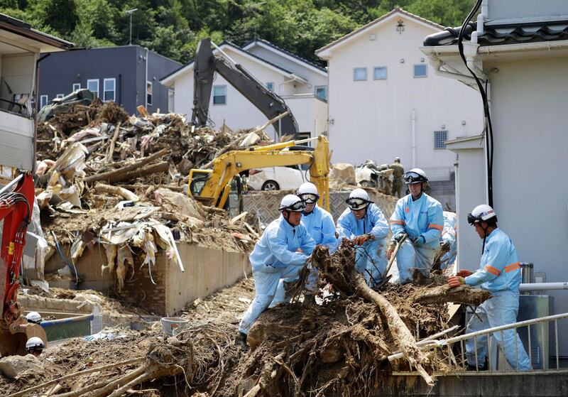 Rescuers remove driftwood from a residential area after flooding caused by heavy rains hit Kumano town, Hiroshima prefecture, southwestern Japan, Thursday, on July 12, 2018. Kyodo News via AP