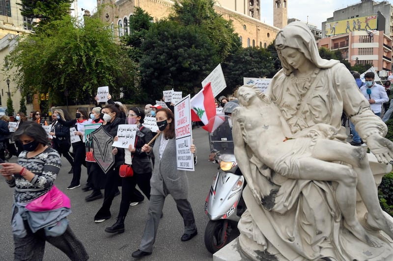 Lebanese women carry placards as they march on the occasion of Mother's Day under the slogan 'Mother's Cry', in Beirut. EPA