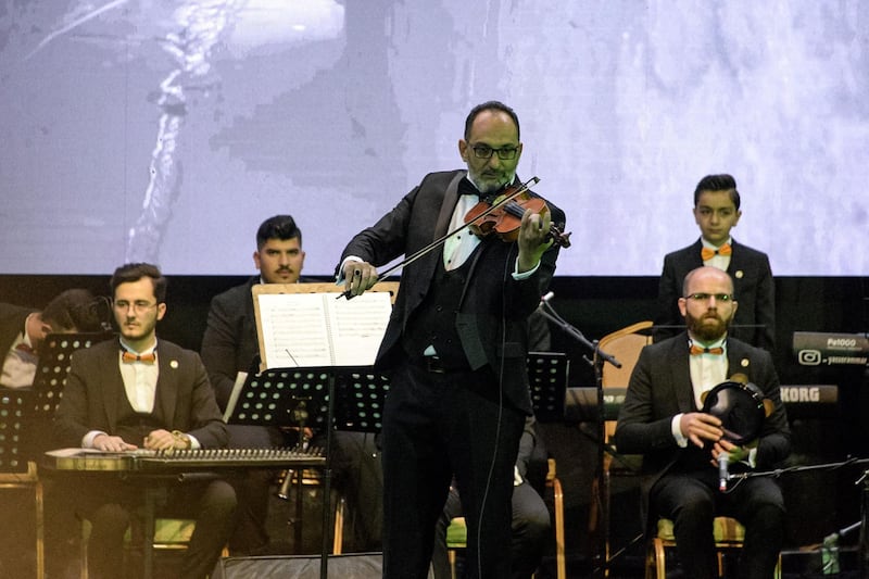 Conductor Mohammed Mahmoud plays the violin while leading the Watar orchestral ensemble, which was formed only five months earlier. AFP