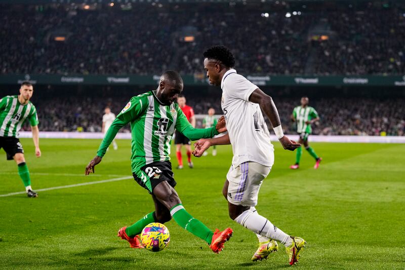 Real Madrid's Vinicius Junior, right, and Betis' Youssouf Sabaly vie for the ball. AP Photo