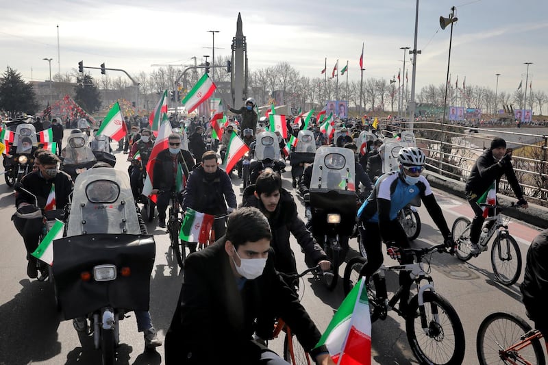 Iranians attend a rally marking the 42nd anniversary of the Islamic Revolution, at Azadi (Freedom) Square in Tehran, Iran, Wednesday, Feb. 10, 2021. Tens of thousands are expected to drive through cities and towns on Wednesday as part of the manifestations after the government decided to replace traditional demonstrations with motorcades as a measure to prevent the spread of the coronavirus.  (AP Photo/Ebrahim Noroozi)
