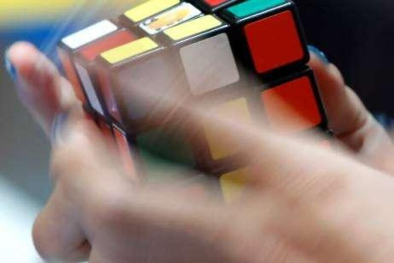 A participant solves Rubik's Cube for speed during 3X3X3 Rubik's Cube Megahouse cup championship in Tokyo, Sunday, July 25, 2010. (AP Photo/Shizuo Kambayashi)