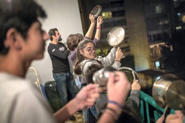 Members of the Hajj family bang pots and pans on their balcony of the flat in Sassine, Beirut, to express their anger at Lebanon's political leaders. Jacob Russell for The National