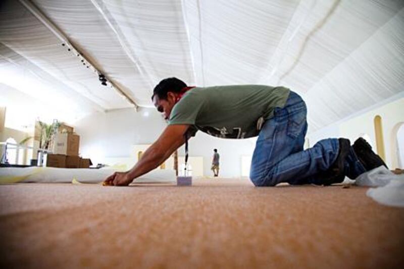 Abu Dhabi, UAE, June 27, 2013:

The Ramadan tent at the Emirates Palace is in the process of being constructed. The venue will host many iftars during the Muslim holy month. The construction of the tent is within itself a vast undertaking. 

Seen here is Bahadur. He is in the process of securing the carpet onto the floor. 



Lee Hoagland/The National  (Photos are for a Business story by Gillian Duncan on Ramadan working hours). 