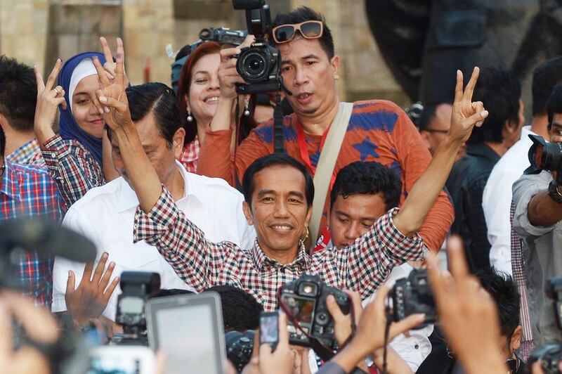 Indonesian presidential candidate Joko Widodo, centre, flashing the victory sign after delivering a speech at Tugu Proklamasi square in Jakarta on July 9, 2014. Both he and his rival Prabowo Subianto have claimed victory to the July 9 presidential polls. Adek Berry/AFP Photo