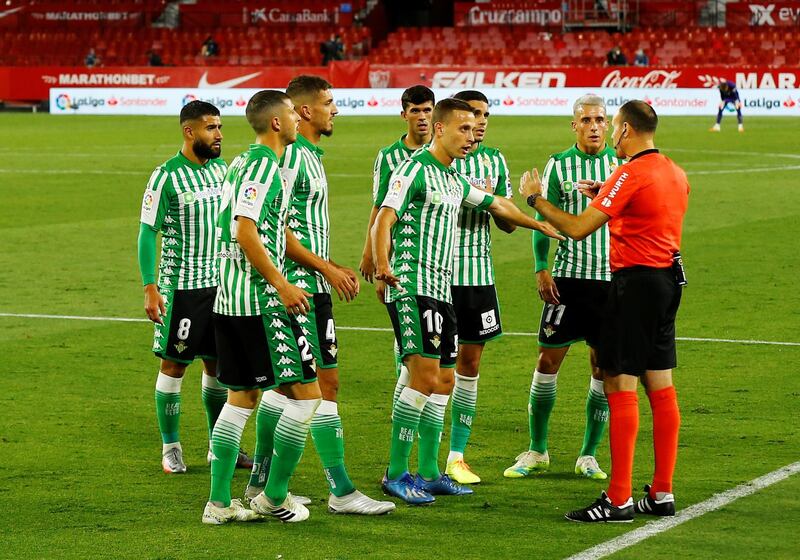 Real Betis players remonstrate with referee Antonio Lahoz after he awarded a penalty to Sevilla. Reuters