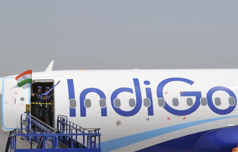 (FILES) In this file photograph taken on March 16, 2016, crew members of an IndiGo Airbus A320 aircraft wave an Indian national flag at The India Aviation 2016 airshow at Begumpet Airport in Hyderabad. Airbus announced on October 29, 2019, that India's IndiGo have ordered 300 A320neo aircraft. / AFP / NOAH SEELAM
