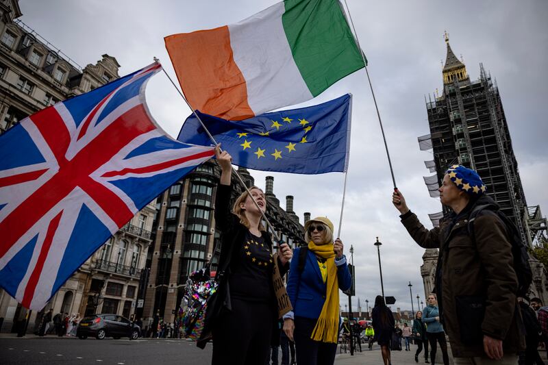 Anti-Brexit protesters wave the flags of the United Kingdom, Ireland and European Union outside Parliament on October 13, 2021. Getty Images