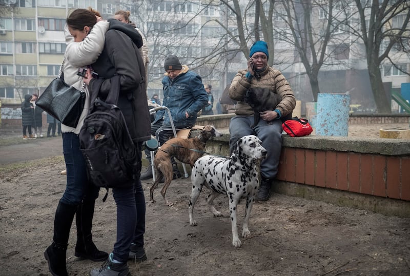 Residents wait outside their building after it was damaged by a Russian missile strike in Kyiv. Reuters