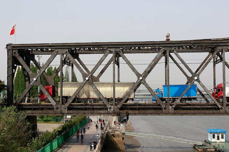 FILE - In this May 24, 2018, file photo, trucks cross the friendship bridge connecting China and North Korea in the Chinese border town of Dandong, opposite side of the North Korean town of Sinuiju. China is far and away the North Koreaâ€™s biggest and most important trade partner, supplying the country with everything from fuel to shrimp chips. Flights by the Northâ€™s national airline to China and the cross-border railway are among the Northâ€™s only regularly used links to the outside world and are absolutely crucial to its economic survival. (Chinatopix via AP, File)
