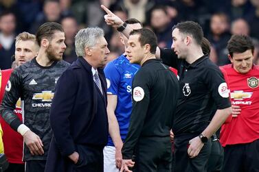 Referee Christopher Kavanagh gestures to Everton's manager Carlo Ancelotti, center left, after showing him a red card during the English Premier League soccer match between Everton and Manchester United at Goodison Park in Liverpool, England, Sunday, March 1, 2020. (AP Photo/Jon Super)