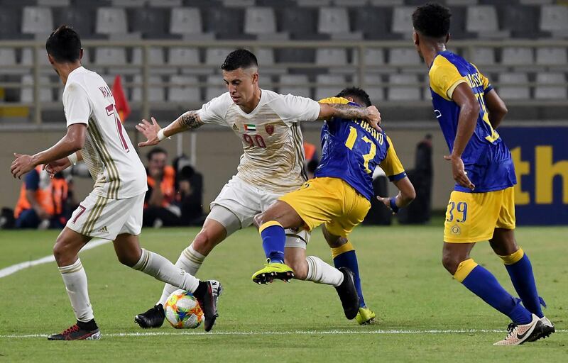 Al Wahda's  Nicolas Milesi, left, fights for the ball with Al Nassr's Abdurahman al-Obaid. AFP