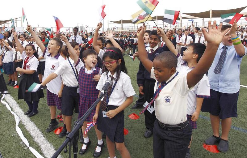 Gems pupils and staff celebrate after breaking the Guinness World Record for the largest number of nationalities singing a national anthem at the same time in 2014. About 100,000 pupils and staff from across the school network took part. Jeffrey E Biteng / The National