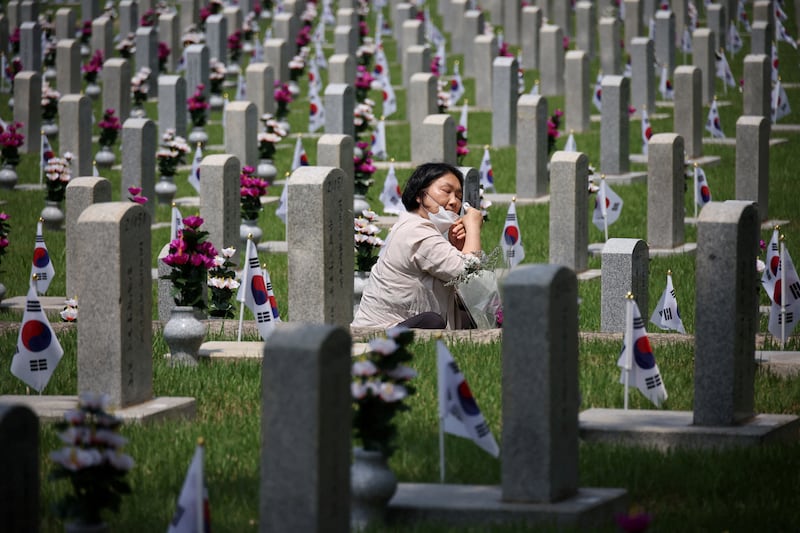 A woman mourns at the gravestone of a family member who died for the country, on the eve of Korean Memorial Day in Seoul, South Korea. Reuters