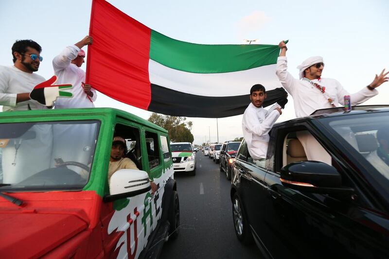 The flag is raised high on the streets of Umm Al Quwain. Music and car horns were also features of the festivities. Pawan Singh / The National 