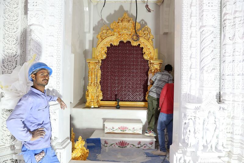 Workers polish a gold-plated frame, inside which Hindu statues will be placed. Pawan Singh / The National