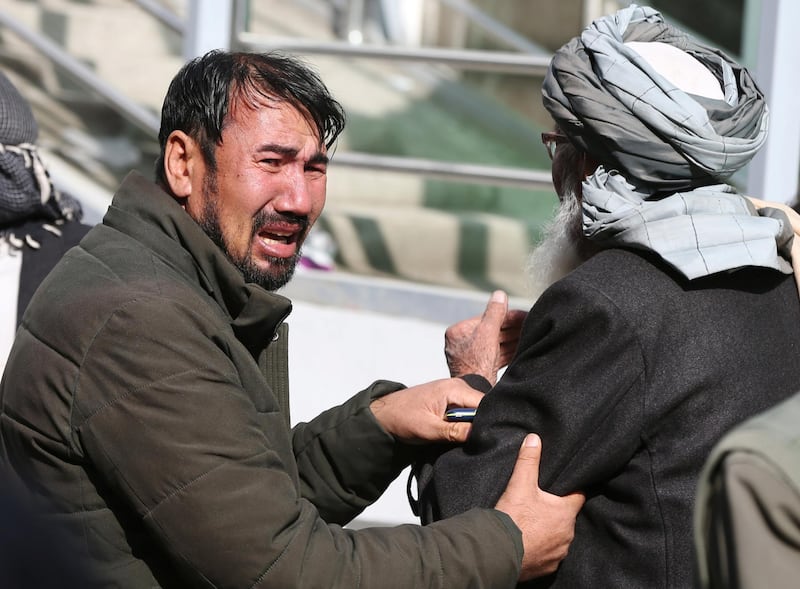 Afghan men cry at a hospital after they heard that their relative was killed during an attack in Kabul, Afghanistan. REUTERS