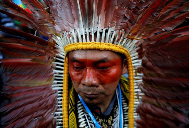 An indigenous man wearing a feathered headdress attends a climate change protest march, as COP25 climate summit is held in Madrid, Spain. Reuters