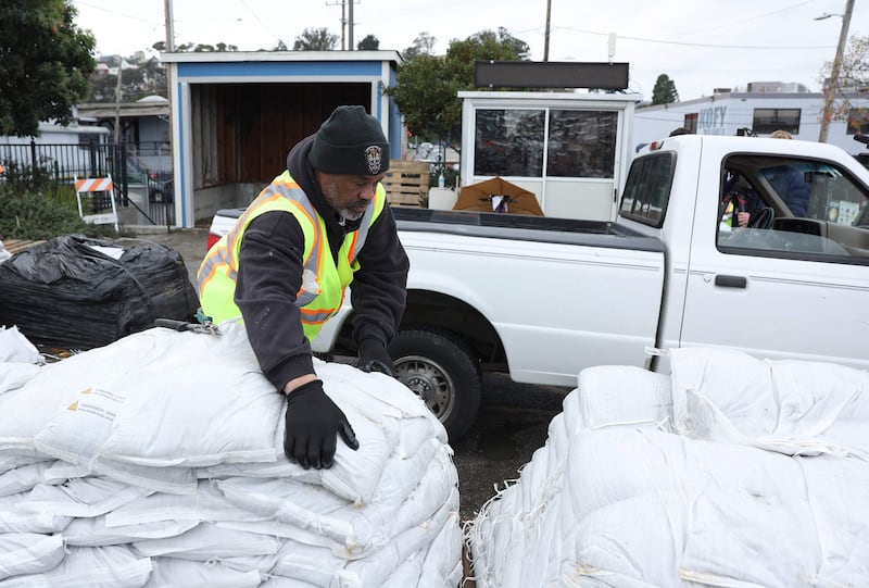 A San Francisco Department of Public Works worker loads sandbags into a lorry. Getty / AFP