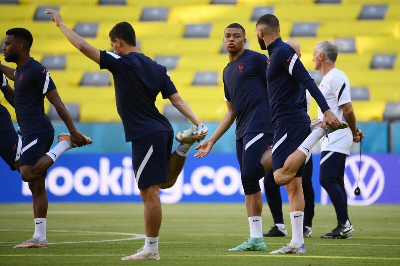 Kylian Mbappe and Karim Benzema stretch during a training session at the Allianz Arena. AFP