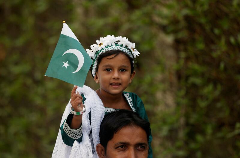 A girl holds a Pakistan flag as she sits on the shoulders of her father during a ceremony to celebrate the country's 70th Independence Day at the mausoleum of Muhammad Ali Jinnah in Karachi. Akhtar Soomro / Reuters