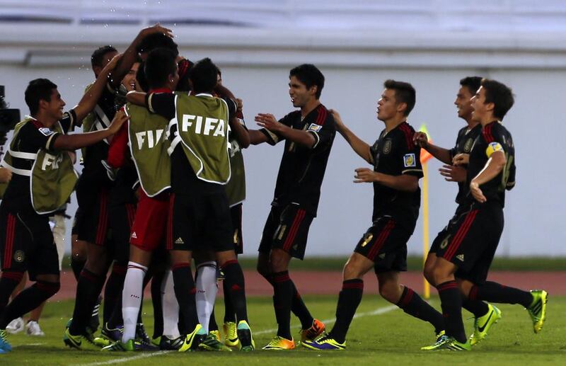 Mexico players celebrate after scoring against Iraq. Karim Sahib / AFP