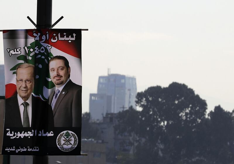 A poster of Lebanese Prime Minister Saad Hariri and President Michel Aoun is seen erect on a street lamp on a highway in the capital Beirut on November 17, 2017.
Arabic writting on poster reads "Lebanon First, 10425 KM2." / AFP PHOTO / JOSEPH EID