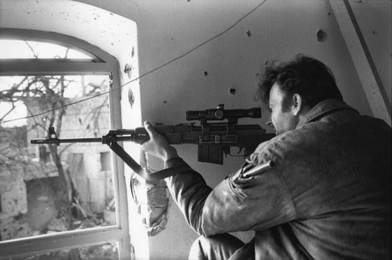 A Serbian sniper fires through a window in Brcko, in north-eastern Bosnia, in March 1993. Getty Images